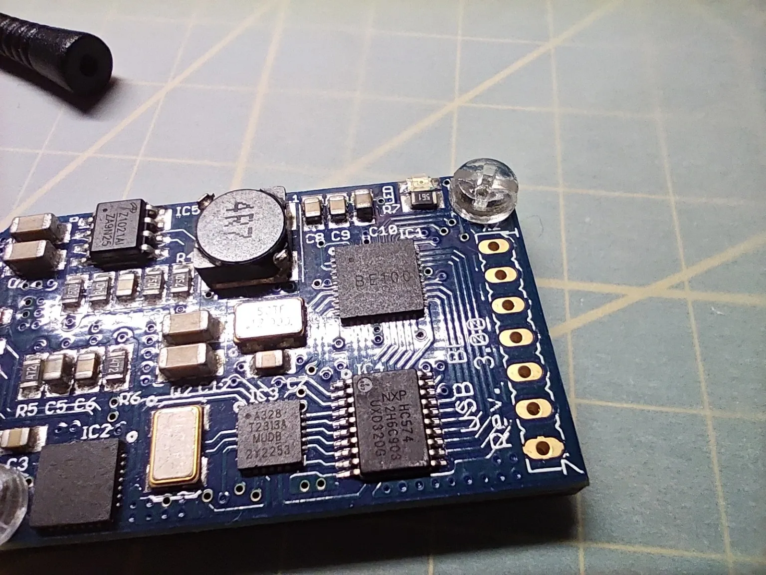 Detail modré desky USB Block Erupter se Silicon Labs CP2102, logikou 74HC574 a dalšími součástkami.